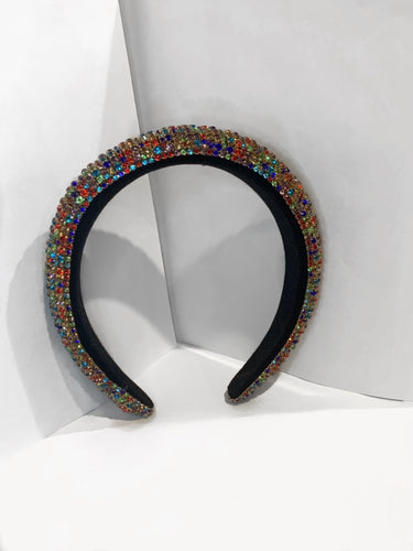 Headband covered in multi colored gems, black on the inside with cushion.